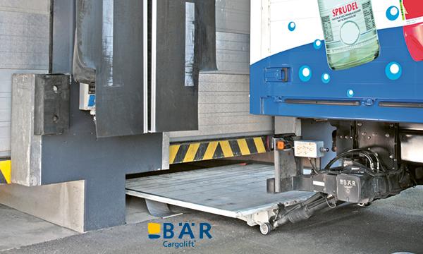 La piattaforma BAR Lift del camion delle bevande viene posizionata sotto una rampa per il carico.