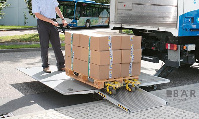 L'autista guida sul marciapiede attraverso un ponte di accesso alla piattaforma della sponda idraulica BAR.